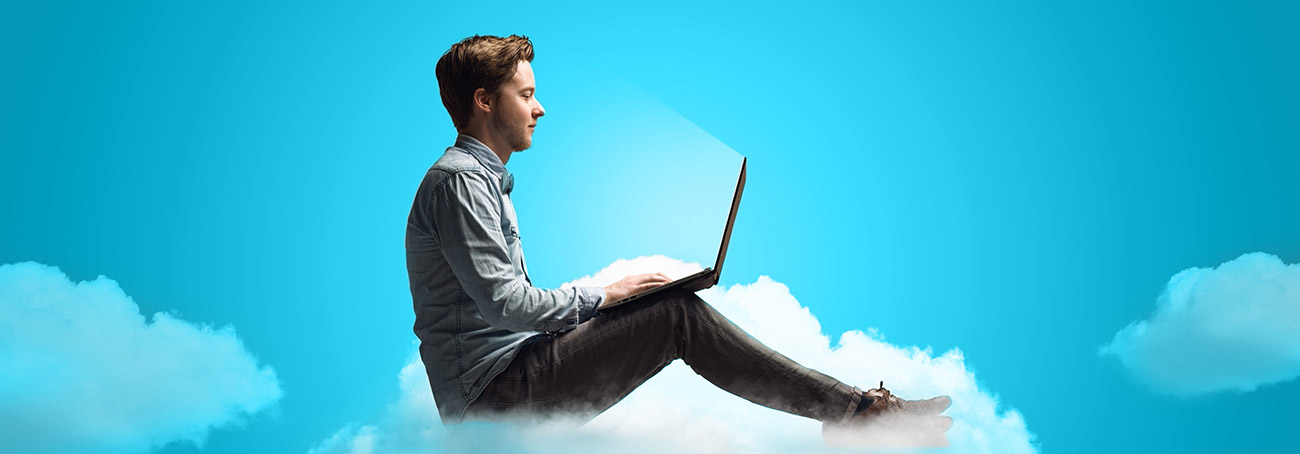 Mann mit Laptop auf Cloud